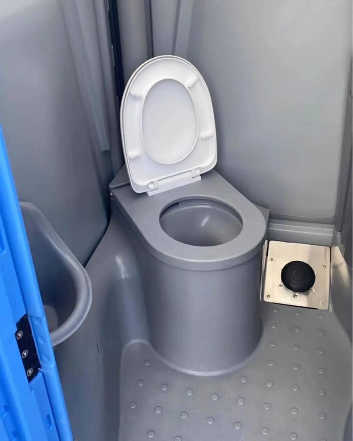 Inside a flushing portable toilet with a raised seat