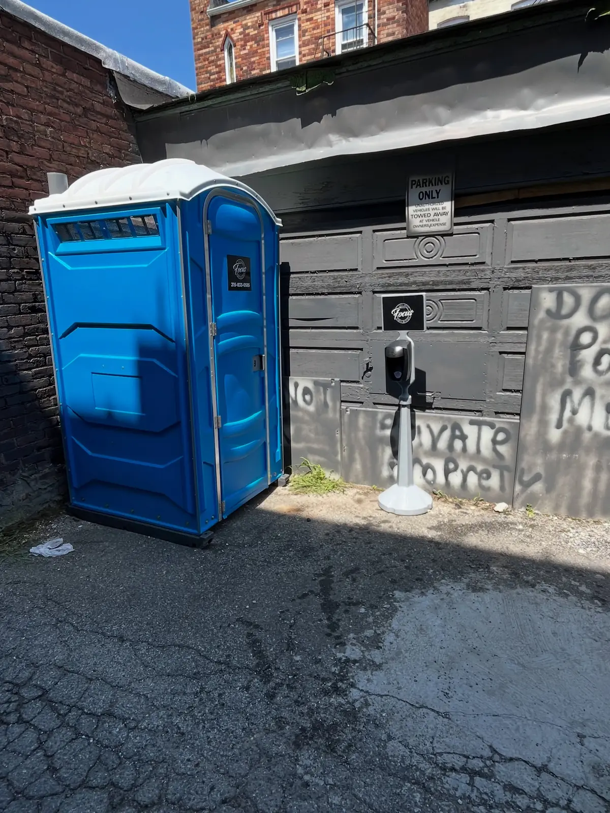 Porta potty with a hand-wash station beside it