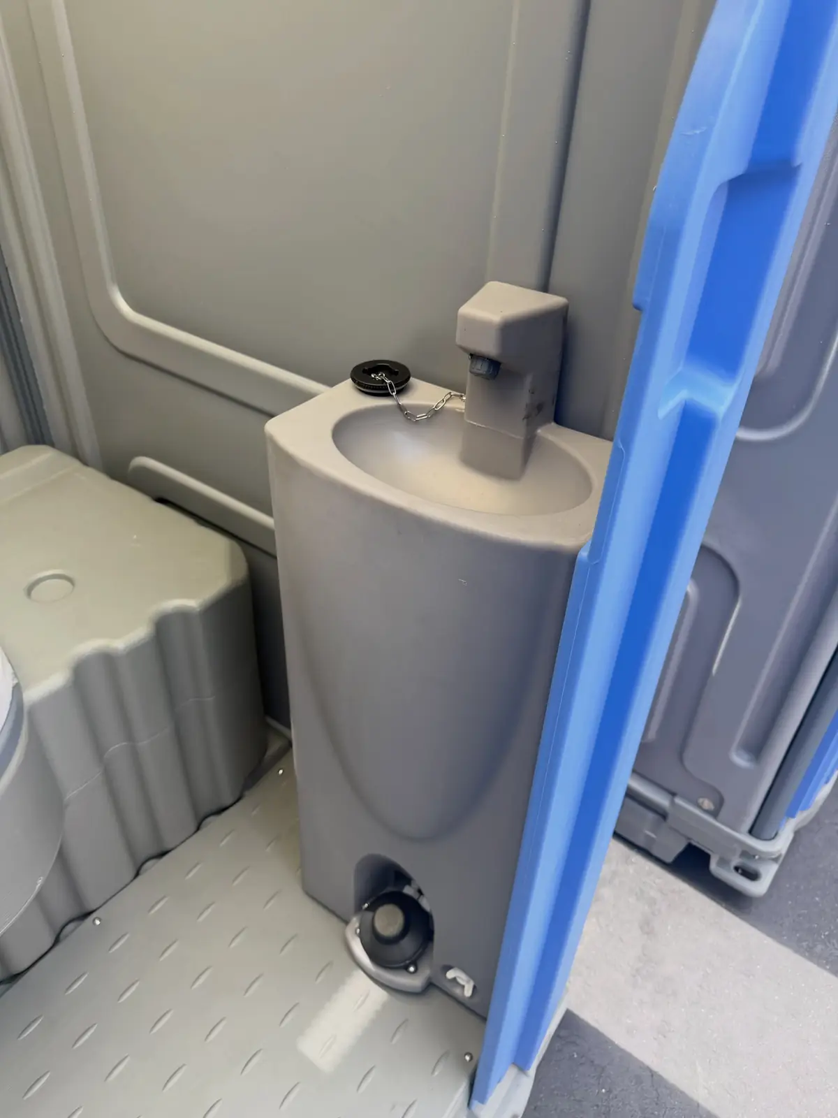 Foot-pump sink inside a portable toilet