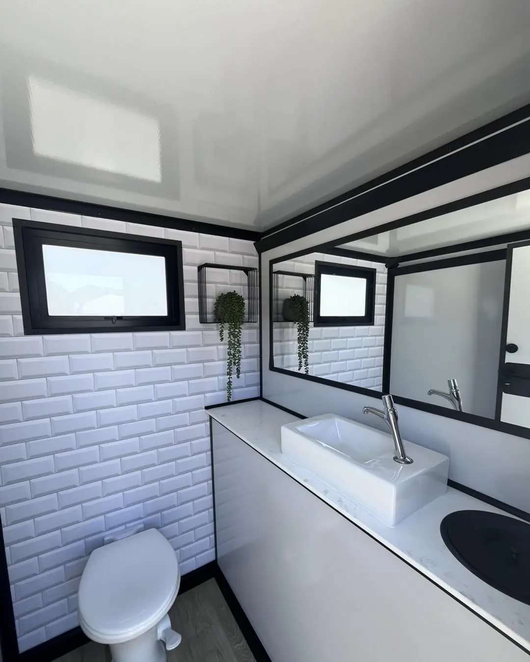 Tiled restroom trailer interior with sink and window