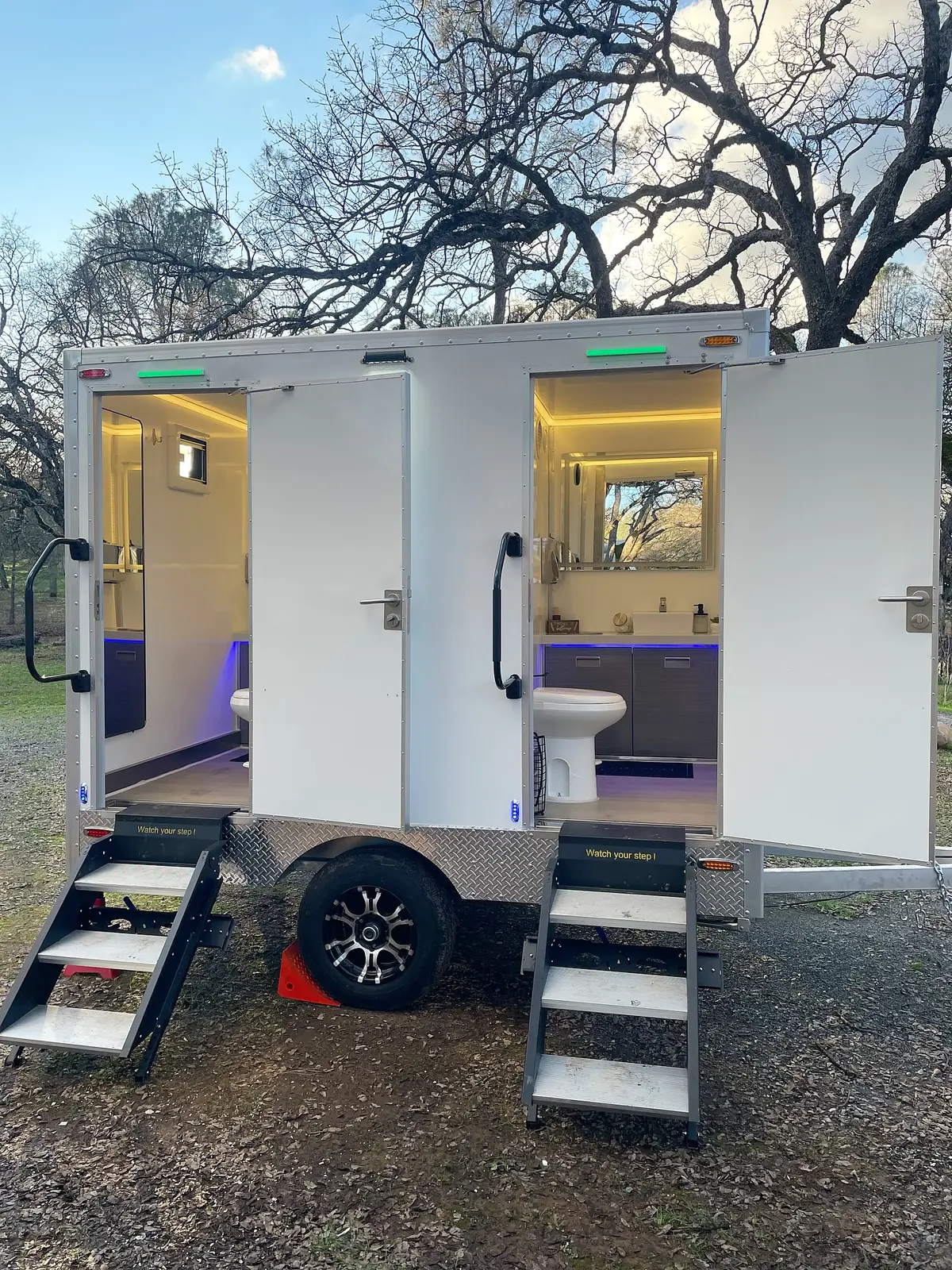 Two-stall restroom trailer with separate doors and steps